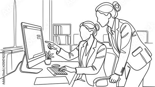 Two professional women collaborating on a project using a computer at an office desk.