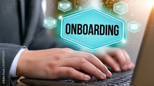 Business professional typing on laptop with digital onboarding interface graphics concept for human resources training processes.