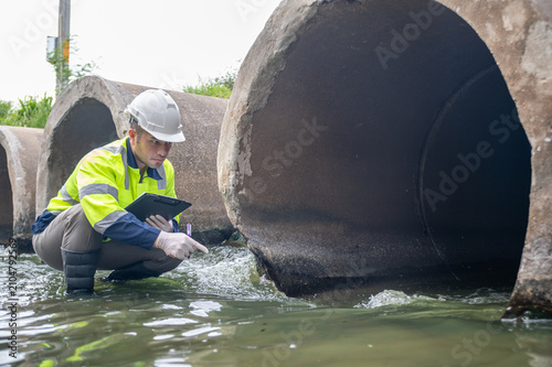Fotografie A specialist engineer is inspecting impurities in the water being discharged into a stream