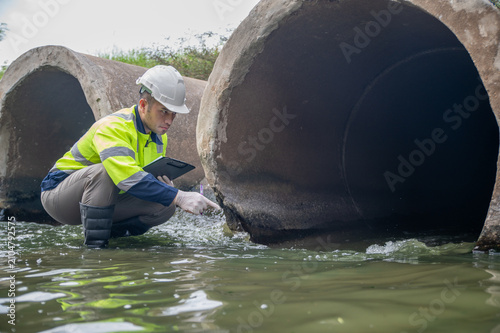 Foto A specialist engineer is inspecting impurities in the water being discharged into a stream