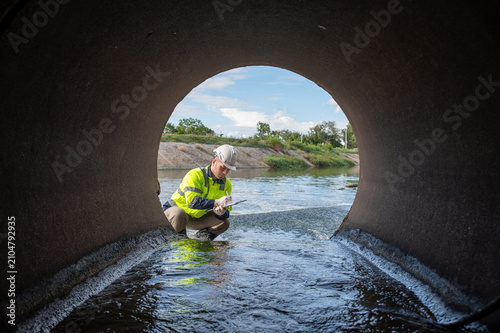 Fotografía A specialist inspector is examining the drainage system of a large factory