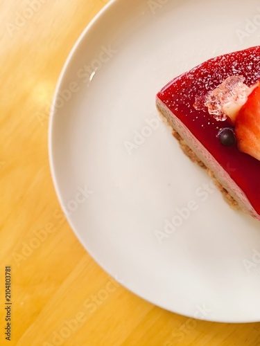 A delectable slice of cake with rich layers of cream and frosting, topped with fresh fruit or sprinkles. Perfect for dessert photography, showcasing indulgence and sweetness in food-related projects.