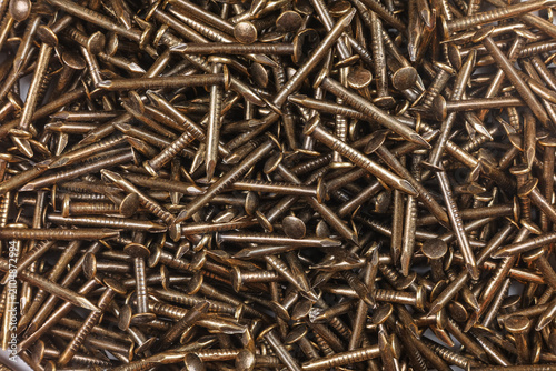 Background image: texture of copper decorative small nails scattered on the surface