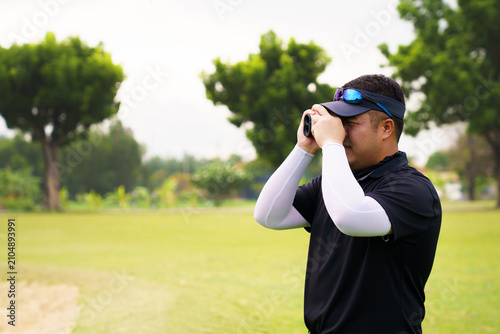 Canvastavla Golfer looking through laser rangefinder to measure distance