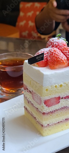 A delectable slice of cake with rich layers of cream and frosting, topped with fresh fruit or sprinkles. Perfect for dessert photography, showcasing indulgence and sweetness in food-related projects.