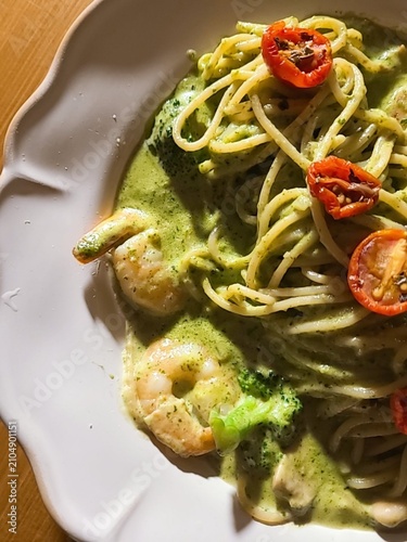 Basil spaghetti made with al dente pasta tossed in fragrant basil sauce, blended with olive oil and garlic, creating a simple yet flavorful dish with fresh green color and aromatic taste