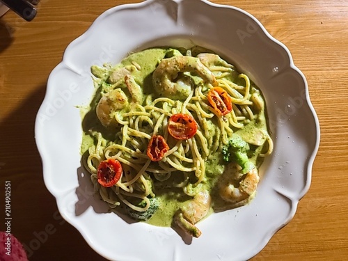 Basil spaghetti made with al dente pasta tossed in fragrant basil sauce, blended with olive oil and garlic, creating a simple yet flavorful dish with fresh green color and aromatic taste