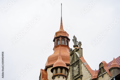 Ornate Tower Spire with Copper Roof and Statue on Historic Building