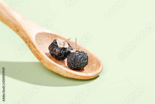 Foto Qinghai Black Wolfberries on Wooden Spoon - Traditional Chinese Superfood Still