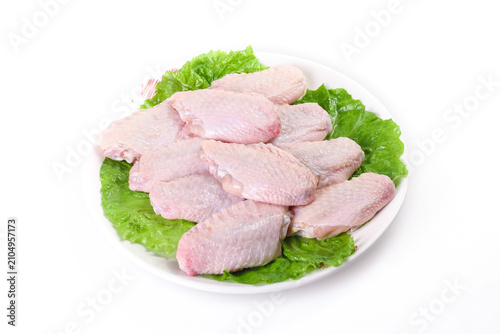 Quadro su tela Raw Chicken Wings on White Plate with Fresh Lettuce - Uncooked Poultry Meat for