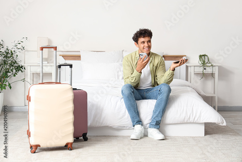 Young man sitting on a bed ...