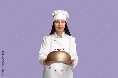Female chef with metal tray...