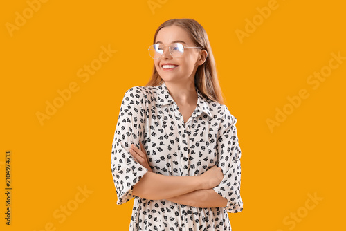 Foto Young woman in eyeglasses on yellow background