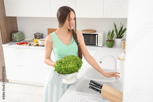 Young woman washing fresh l...