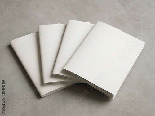 Stack of blank white notebooks or brochures with paper covers on a gray surface. magazine mockup psd 