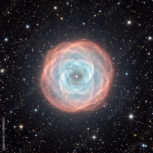 Small planetary nebula glowing blue green and pink shells centered on black starfield