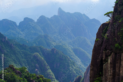 A scenic view of the lush green peaks and rocky cliffs at Sanqingshan Mountain in Jiangxi province of China on a clear day