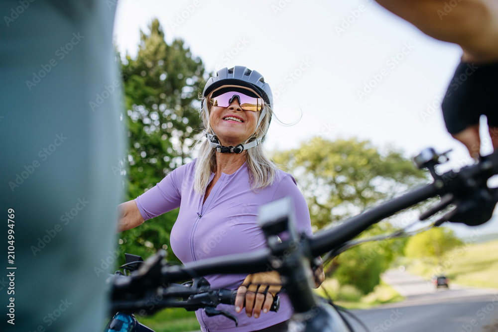 Fototapeta premium Active senior couple preparing for electric bike trip.