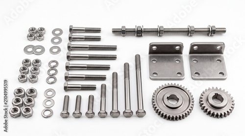 Collection of stainless steel bolts nuts washers gears and metal brackets arranged on white background
