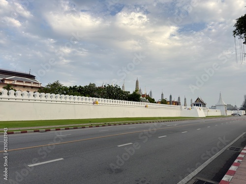 Cuadro en lienzo Empty asphalt road beside a white ornate balustrade wall with distant trees and
