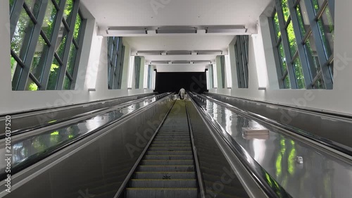 People go up on the escalator. Elevator on continual movement.