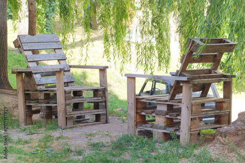 Outdoor chairs made from wooden pallets. Recycling used commercial pallets to create functional furniture. Food court interior. Sunny summer day.