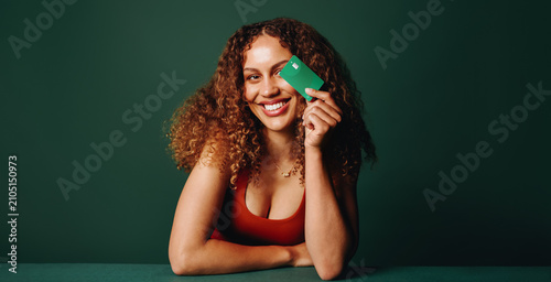 Card presented by the woman in a green studio portrait for membership and payment