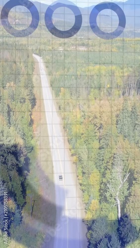 Vertical video: Drone shadow starting UI, collecting data while dark SUV moving along forest road