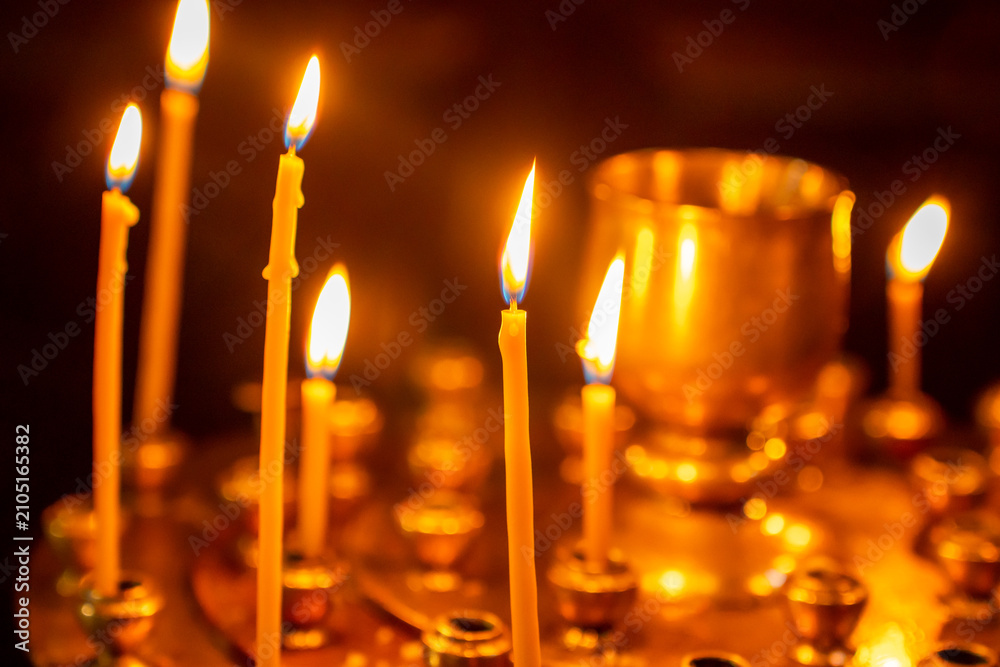 Obraz premium Many burning wax candles in the orthodox church or temple