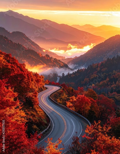 A winding mountain road cuts through vibrant autumn foliage under a golden sunrise.