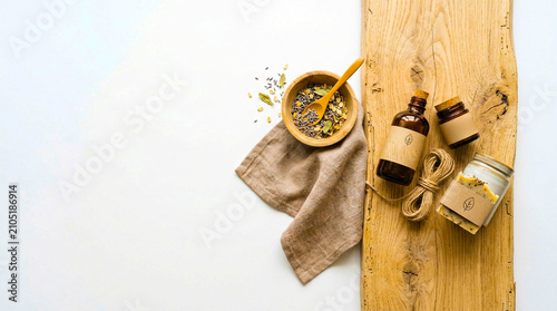 Natural organic cosmetic ingredients on rustic wooden board with apothecary jars