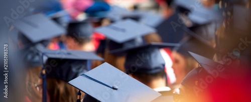 Принти на полотні Graduates wear caps in a sea of dark tones
