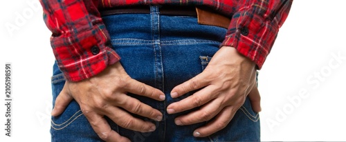 Bilde på lerret Man in red plaid shirt grips his backside