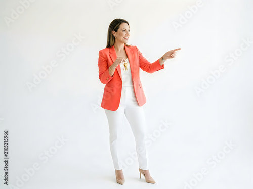 Confident businesswoman in coral blazer pointing at copy space, professional female leader gesturing on white background, successful corporate entrepreneur