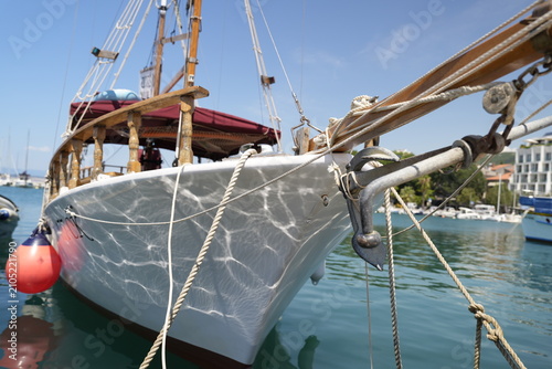 Fotografi Traditional Wooden Sailing Boat Moored In Sunny Marina