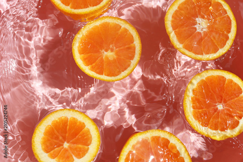 Canvas Print Juicy Cara Cara orange slices floating in clear, rippling water.