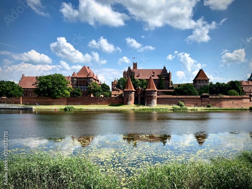 фотографія Malbork Castle in Poland, a UNESCO World Heritage site, stands majestically beside the Nogat River