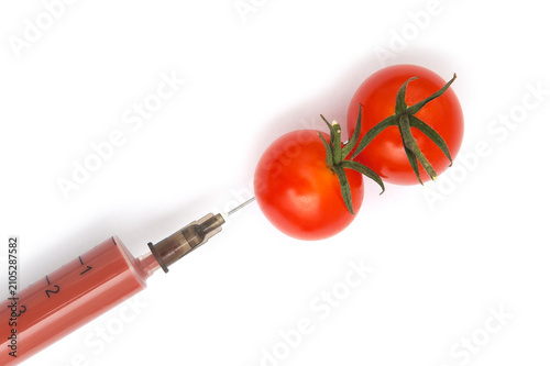 GMO vegetables. Two red tomatoes and dye injections on a white background.