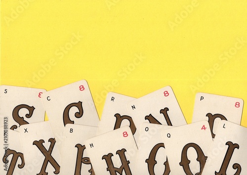 Tableau sur toile A montage of vintage alphabet playing cards on a bright yellow background with space for text or copy