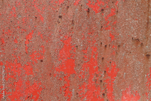 Weathered red peeling paint on rusty metal with distressed industrial texture background