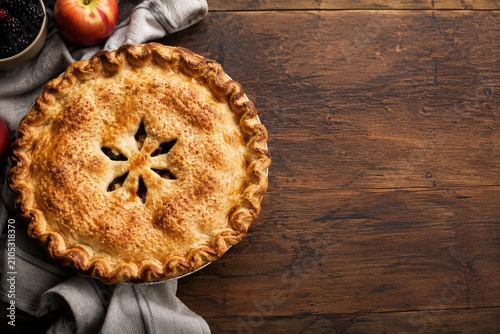 Thanksgiving apple pie with fresh fruit and cloth on a rustic wooden table autumnal harvest celebration