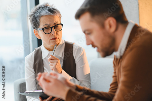 Counselor listening to man talking during therapy session