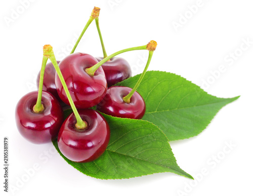 Ripe sweet cherries with green leaves isolated on white background