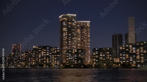 運河沿いに立ち並ぶ高層マンションが見える夜の風景。