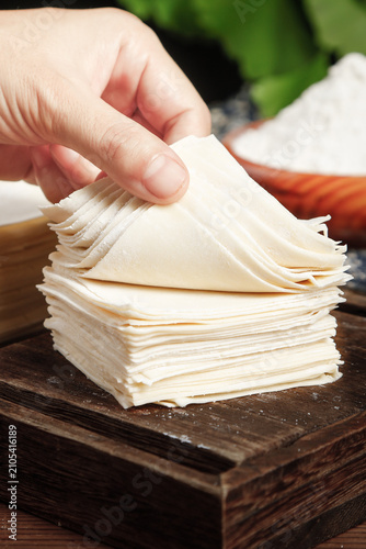 Handmade Wonton Skins - Thin Dumpling Wrappers Stack on Wooden Board for Traditional Chinese Cooking