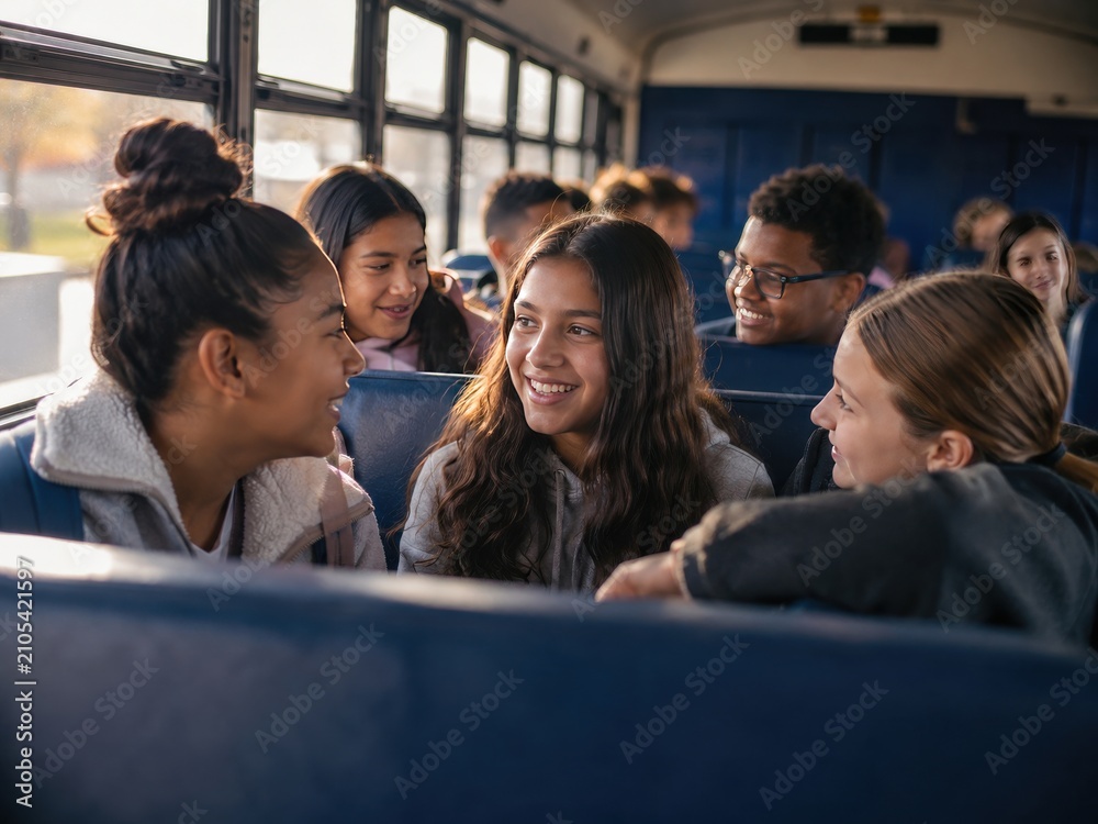 Obraz premium Diverse Group of Happy Teenagers Talking and Laughing Together on a School Bus During Their Morning Commute to High School