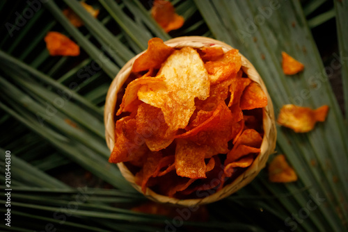 Crispy Sweet Potato Chips in Bowl on Palm Leaves