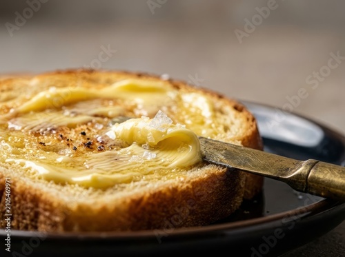Butter Spread on Toasted Brioche with Salt Crystals and Knife - Culinary Close-Up