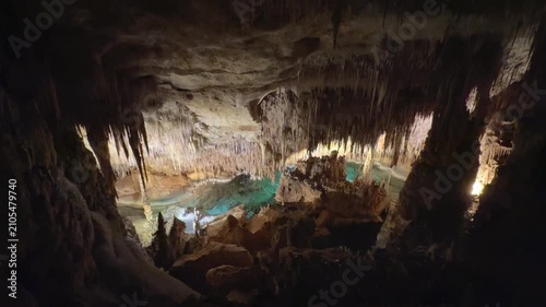 Nature view inside dark dragon cave. Tourist attraction: caves stalactites and stalagmites rock formations blue water lake river. town Porto Cristo Mallorca Spain. vertical video Cuevas del Drach.