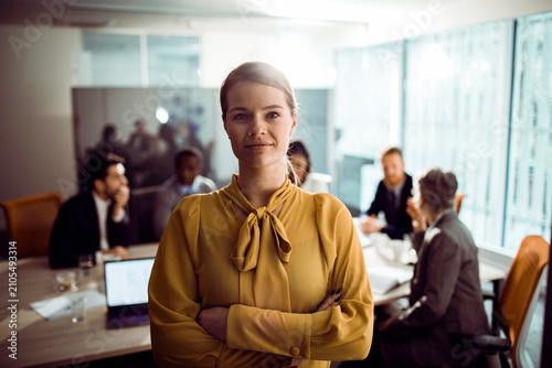 Confident businesswoman leading team meeting in modern office